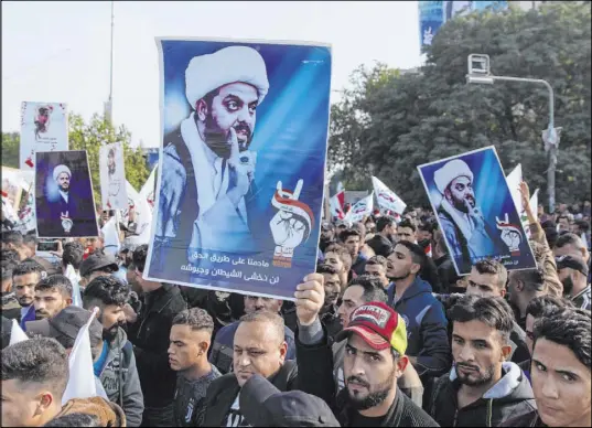  ?? Nasser Nasser The Associated Press ?? Protesters chant anti-U.S. slogans and carry posters with pictures of leader Qais al-Khazali during a rally for the Shiite group Asaib al-Haq on Saturday in Baghdad. They were protesting recent sanctions against leaders of Asaib al-Haq and other groups.
