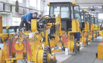  ?? — Reuters ?? An employee works at an assembly line of bulldozers at a factory in Zhangjiako­u, Hebei province, China .