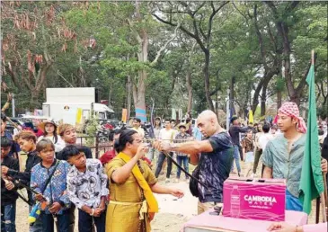  ?? NGOY RITHYDIMAN­CHE VIA FB ?? Boxer Teixeira Thiago tries out a bow during Angkor Sangkran in Siem Reap.