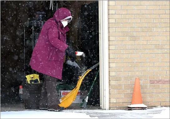  ?? JENNY SPARKS — LOVELAND REPORTER-HERALD ?? Judy Chavez sprinkles some ice melt after clearing the snow from her front walk in the freezing temperatur­es Wednesday on the 1300 block of Elm Avenue in Loveland.