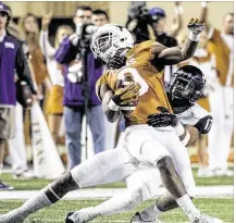  ?? RICARDO B. BRAZZIELL / AMERICAN- STATESMAN ?? Texas wide receiver John Harris, tackled by TCU’s Sam Carter, picked up 39 yards on fifive catches Thursday to become the sixth Longhorns player to top the 1,000-yard mark.