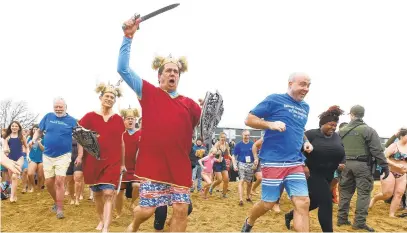  ?? PAUL W. GILLESPIE/CAPITAL GAZETTE ?? Vikings from the Rock Creek Council of the Knights of Columbus, led by Alex Lieb, run to the water for the first plunge.