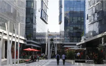  ??  ?? MEN WALK near hi-tech firms’ offices in Tel Aviv.