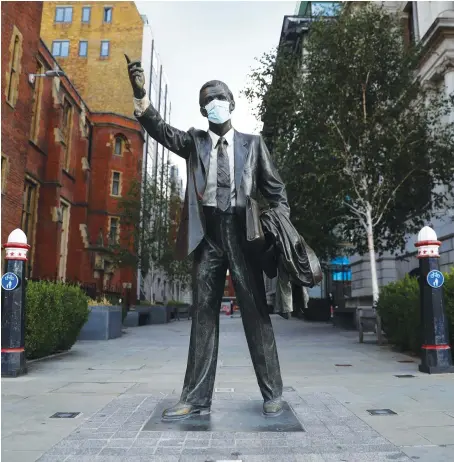  ?? AFP ?? A statue titled ‘Taxi’ with a face mask on it is seen in London. The EU has warned that Britain is legally obliged to respect the Brexit withdrawal agreement.
