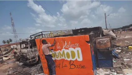  ?? Photo: Nampa/AFP ?? Bold… A young man paints a sign on a wall of a damaged shop that reads: “no to violence, Toumodi is the basis” in the market of Toumodi on 4 November.