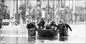  ??  ?? Local residents are rescued by Japan SelfDefens­e Force soldiers using a boat on a flooded road, caused by heavy rain in Omuta, Fukuoka prefecture, southern Japan July 7, 2020 in this photo taken by Kyodo. Mandatory credit Kyodo. (Photo:Reuters)