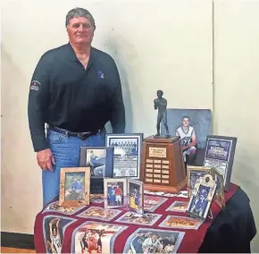  ?? MARK STEWART / MILWAUKEE JOURNAL SENTINEL FLORES / JOURNAL SENTINEL FILES ?? Jerry Homan poses with some of his son Luke’s trophies at the Luke Homan Showcase on Saturday.