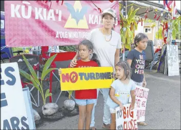  ?? Jennifer Sinco Kelleher The Associated Press ?? Sunny Unga and her daughters Joanne, from left, Alana and Ina protest the constructi­on of eight wind turbines in Kahuku, Hawaii, on Oct. 30.