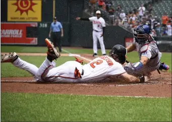 ?? NICK WASS — THE ASSOCIATED PRESS ?? Baltimore Orioles’ Gunnar Henderson, left, slides home against Los Angeles Dodgers catcher Austin Barnes to score on a double by Ramon Urias during the first inning of a baseball game Wednesday, July 19, 2023, in Baltimore.