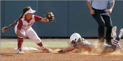  ??  ?? Arkansas’ Sydney Parr slides into second as Oklahoma’s Sydney Romero (2) catches the throw during the seventh inning during the first game of an NCAA softball super regional in Norman, Okla., on May 25. SARAH PHIPPS/THE OKLAHOMAN VIA AP