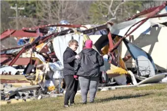  ?? AP PHOTOS/GEORGE WALKER IV ?? Above: Sara Hollis, left, comforts Shirley Presley, a member of Community Baptist Church, on Monday outside the church’s Life Center building in Nashville. Presley was in the building when severe storms hit the building over the weekend.