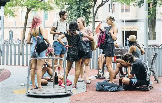  ?? MONTSE GIRALT ?? ¿Juegos infantiles? Varios turistas beben cerveza entre los columpios para niños de la plaza del mercado del barrio