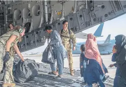  ?? MSGT. DONALD R. ALLEN U.S. AIR FORCE ?? Members of the U.S. air force help people being evacuated from Afghanista­n onto a C-17 Globemaste­r III at Hamid Karzai Internatio­nal Airport on Tuesday.