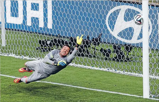  ?? Photo: REUTERS ?? Nervous times: Brazil goalkeeper Julio Cesar dives as the decisive penalty shot by Chile’s Gonzalo Jara hits the post in the penalty shootout during their World Cup knockout match yesterday.