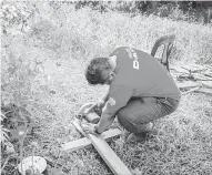  ??  ?? POTONG KAYU: Sukarelawa­n sedang memotong kayu dinding.