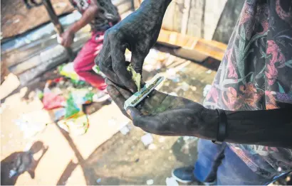  ?? Picture: Jacques Nelles ?? NYAOPE. An addict is seen rolling a marijuana joint laced with white ‘nyaope’ powder yesterday in Soshanguve, where 250 addicts had left a rehab centre for ‘lack of resources’.