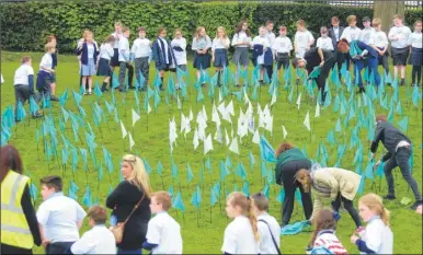  ??  ?? Homewood School pupils placed their flags in a circle to create the Tenterden Schools Trust logo; around 3,000 pupils and staff members now make up the new trust