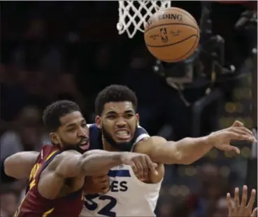  ?? TONY DEJAK — THE ASSOCIATED PRESS ?? Tristan Thompson and the Timberwolv­es’ Karl-Anthony Towns battle for a loose ball in the second half Nov. 26 .