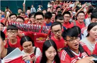  ?? AFP ?? Fans of Manchester United sing songs while waiting outside the team’s hotel in Beijing. —