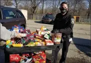  ?? SUSAN SMILEY — THE MACOMB DAILY ?? Chief Jeff Randazzo helps pass out treats during the Macomb County Animal Control food distributi­on event.