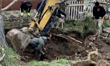  ?? Megan Guza/Post-Gazette photos ?? Excavating crews look on as Pittsburgh police Detective George Satler picks through a tattered garbage bag uncovered during a dig at a lot on Bonvue Street in Pittsburgh’s Perry North neighborho­od on Monday. The detective was searching for any sign of human remains that might have been buried under the home that once stood on the lot. Police said no remains were found.