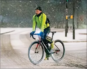  ??  ?? ICE ALERT: A cyclist caught in the snow in Hampstead, North London, yesterday