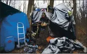  ?? JOHN MUNSON — THE ASSOCIATED PRESS ?? Jose Ortiz eats a boxed meal delivered by volunteers to the residence he built in the homeless encampment known as the Jungle in Ithaca, N.Y., on Dec. 7.