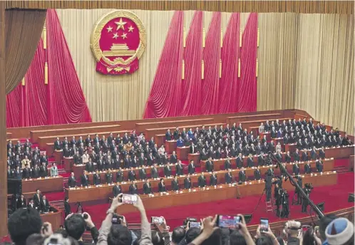  ?? ?? Chinese President Xi Jinping and delegates stand for the national anthem at the closing session of the National Peoples Congress