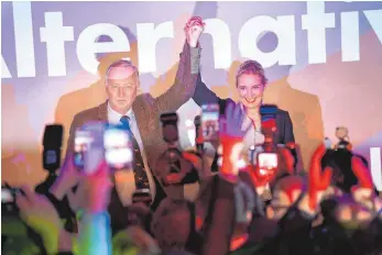  ?? FOTO: DPA ?? Die beiden AfD-Spitzenkan­didaten Alexander Gauland und Alice Weidel freuen sich über den Wahlsieg – die anderen Parteien sehen den Erfolg mit Sorge.