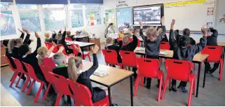  ?? REUTERS FILE PHOTO • ANDREW BOYERS ?? Children wave to friends from separate classes during an online assembly on their first day of school at Holne Chase Primary School in Milton Keynes, Britain, on Sept. 3.