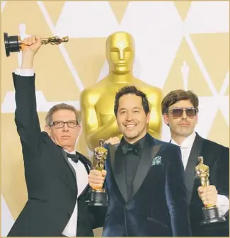  ?? Allen J. Schaben Los Angeles Times ?? JEFFREY MELVIN, left, Paul Austerberr­y and Shane Vieau celebrate their win for production design on “The Shape of Water,” which was nominated for 13 Academy Awards and took four.