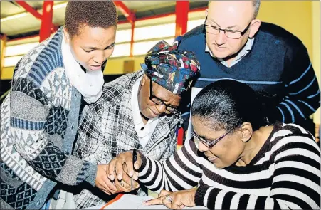 ?? Picture: FREDLIN ADRIAAN ?? BIG MOMENT: Mayor Athol Trollip looks on as Beauty Sitole from the Nelson Mandela Bay Municipali­ty assists Jane Sam, 73 – accompanie­d by her granddaugh­ter Tracey Bless, 21 – with the receipt of her title deed