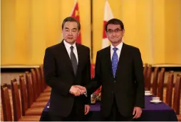  ?? (Reuters) ?? CHINESE FOREIGN MINISTER Wang Yi (left) poses with his Japanese counterpar­t, Taro Kono, yesterday at their meeting in Tokyo.