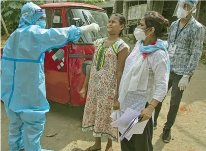  ??  ?? Medical personnel in India taking samples from people to test for coronaviru­s.