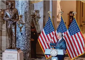  ?? J. Scott Applewhite/Associated Press ?? Rev. Franklin Graham looks up at a bronze sculpture of his father, the late Rev. Billy Graham, after it was unveiled at the U.S. Capitol, where it will stand on behalf of his native North Carolina.