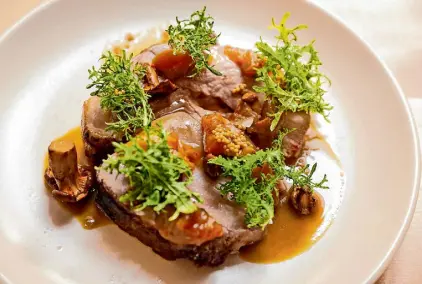  ?? Scott Strazzante/The Chronicle ?? Roasted pork neck with chanterell­es, peach jam and mustard seed jus at Burdell in Oakland.