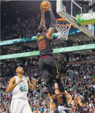  ?? THE ASSOCIATED PRESS ?? Cleveland Cavaliers forward LeBron James dunks in front of Boston Celtics forward Al Horford during the first half in Game 7 of the NBA Eastern Conference finals Sunday in Boston. Cleveland won 87-79.