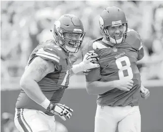  ?? Bob Leverone / Associated Press ?? Vikings offensive lineman Jeremiah Sirles, left, celebrates a touchdown with quarterbac­k Sam Bradford. The Vikings and their 4- 0 record have been one of the NFL’s surprises this season.