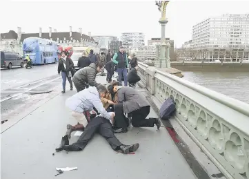  ??  ?? Injured people are assisted after an incident on Westminste­r Bridge in London. — Reuters photo