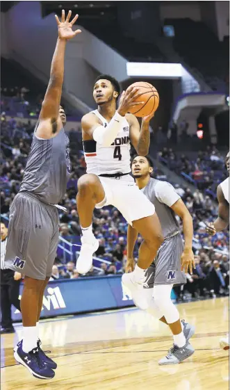  ?? Stephen Dunn / Associated Press ?? UConn’s Jalen Adams scores with seconds left in overtime against Monmouth on Saturday at the XL Center in Hartford. UConn won 84-81. Adams finished with 31 points.