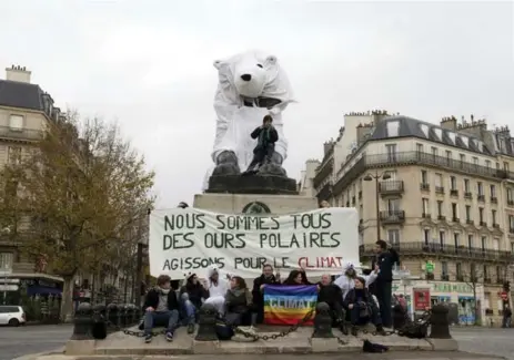  ?? ALAIN JOCARD/AFP/GETTY IMAGES ?? French demonstrat­ors present a banner that translates as “We are all polar bears. Act for climate” in Paris.