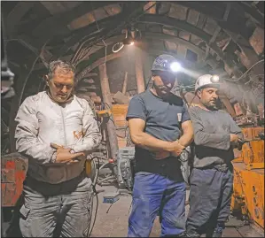  ??  ?? Miners pray after breaking their fast.