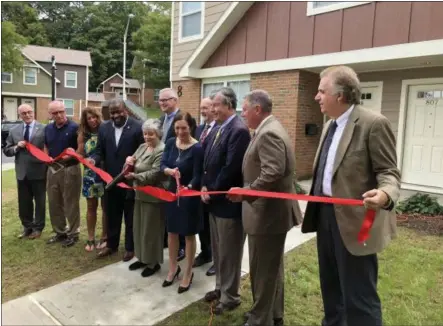  ??  ?? Officials host a ribbon-cutting ceremony Wednesday for the completion of phase one of the rehabilita­tion work at the Martin Luther King Apartments in Troy.