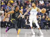  ?? JED JACOBSOHN AP ?? D’angelo Russell, defended by Warriors’ Jonathan Kuminga, had 15 points in first game back with L.A.