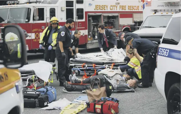  ?? PICTURE: EDUARDO MUNOZ ALVAREZ/GETTY ?? 0 Some of the injured were treated outside the station at Hoboken as police, paramedics and fire service teams raced to the scene