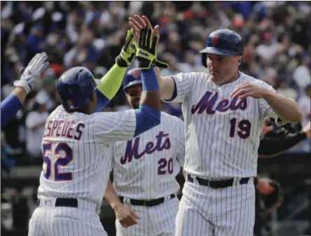  ?? JULIE JACOBSON — THE ASSOCIATED PRESS ?? New York Mets outfielder Jay Bruce (19) celebrates with Yoenis Cespedes (52) and other teammates after scoring on a double by Lucas Duda against the Atlanta Braves during the seventh inning of a baseball game, Monday in New York.