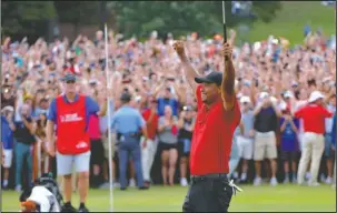  ?? The Associated Press ?? BELIEVE: Tiger Woods celebrates Sunday after picking up his putt for par on the 18th green to win the final round of the Tour Championsh­ip in Atlanta.