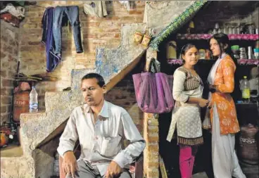  ??  ?? Nikki (second from right) at home with her neighbour and father Chandrashe­khar, who is awaiting a kidney surgery.
