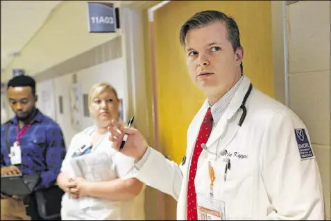  ?? BOB ANDRES PHOTOS / AJC ?? Medical student Justin Kappel discusses a case while a medical team in the geriatric unit at Grady Memorial Hospital makes the morning rounds. Kappel is considerin­g making geriatrics his specialty. That makes him a rarity among young people going into medicine, who tend to view the field as one that offers little prestige.