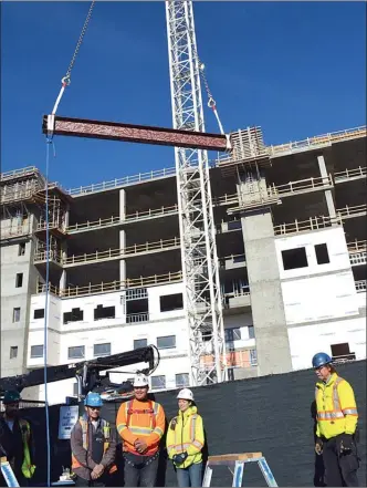  ?? Contribute­d ?? The final steel beam is lifted into place for the six-storey David E. Kampe Tower on Friday. The six-storey tower is phase one of the $312.5-million patient care tower project.